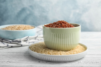 Kitchenware with different types of rice on wooden table