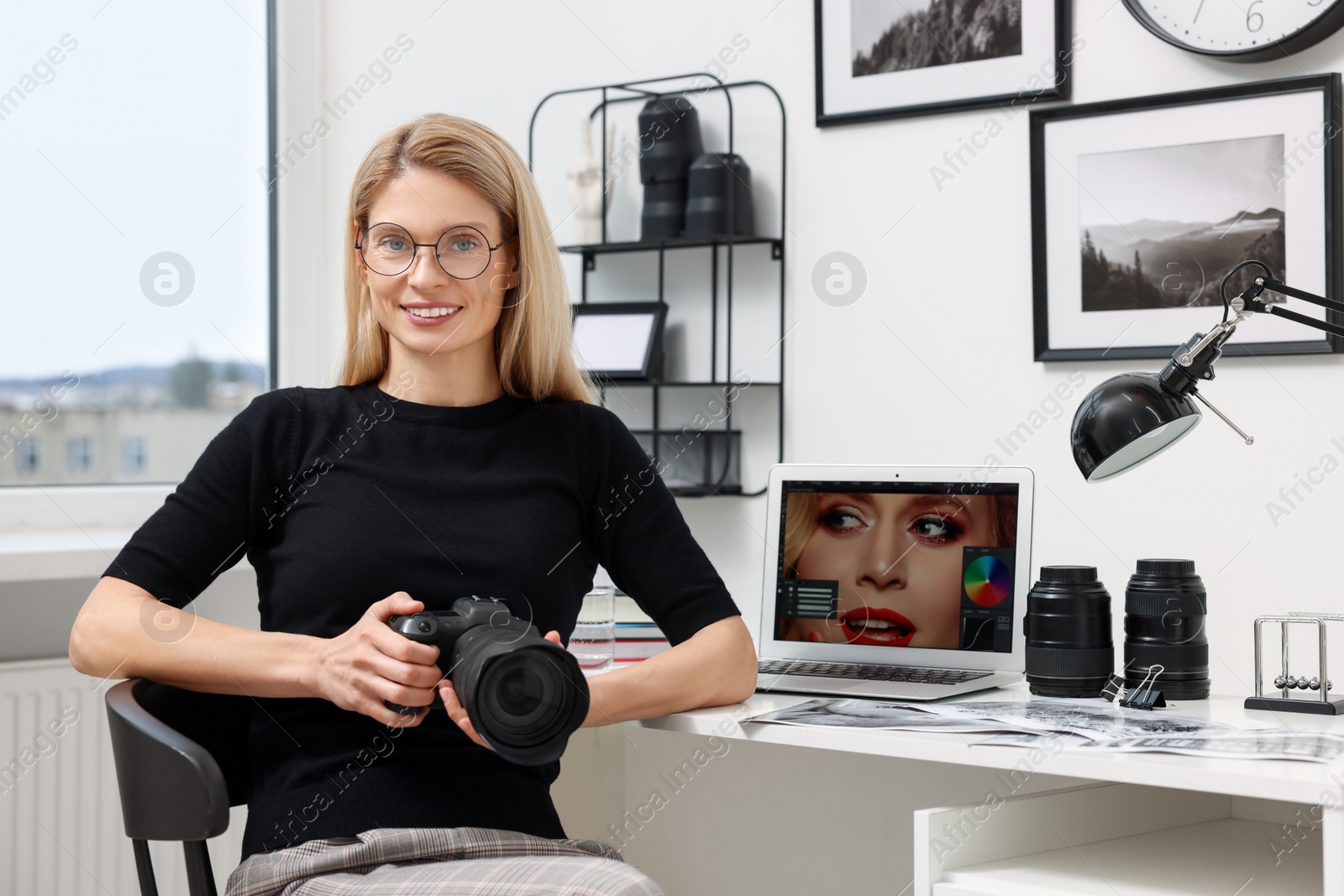 Photo of Professional photographer with digital camera at table in office