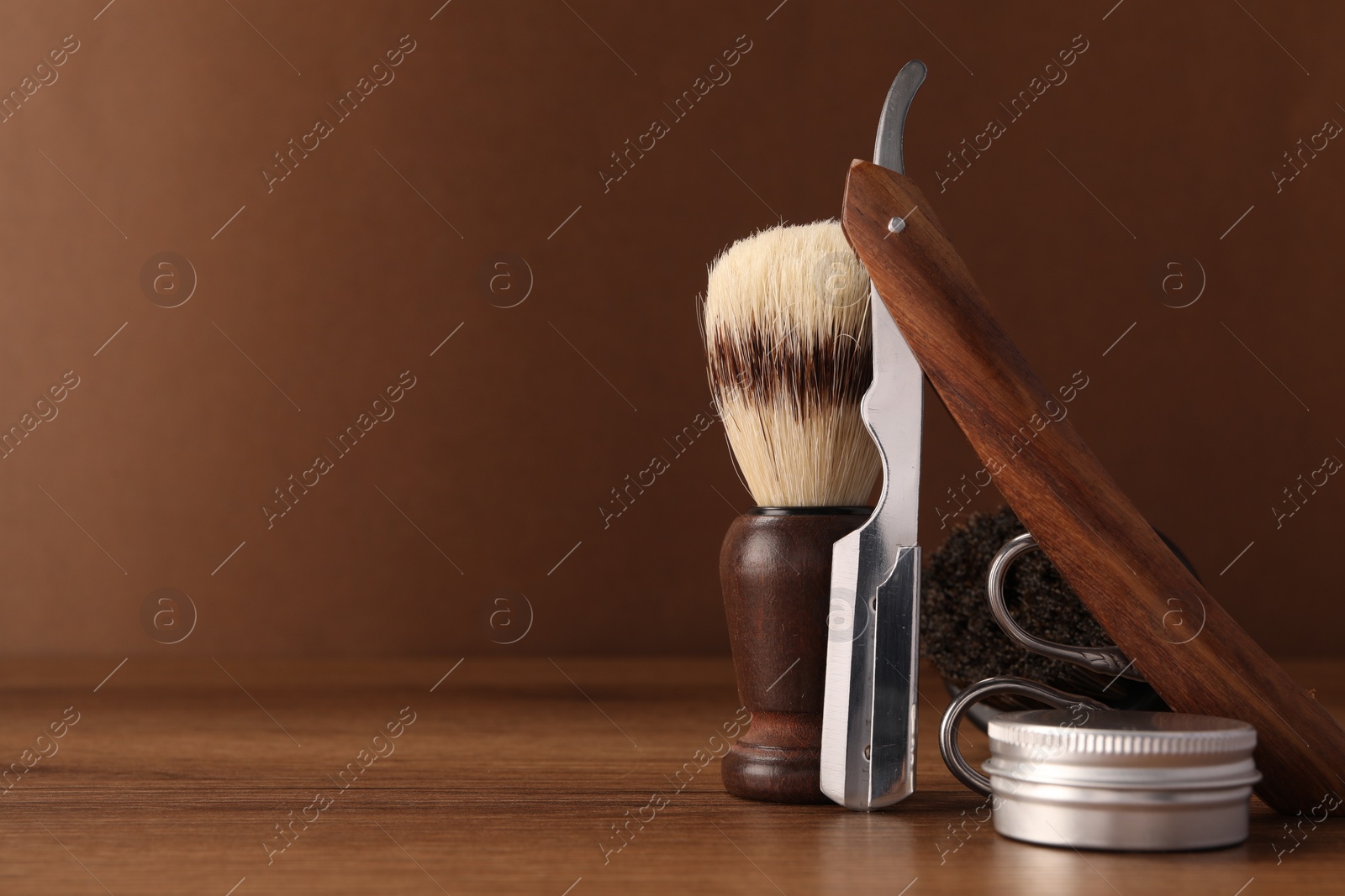 Photo of Moustache and beard styling tools on wooden table. Space for text