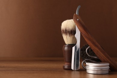 Moustache and beard styling tools on wooden table. Space for text