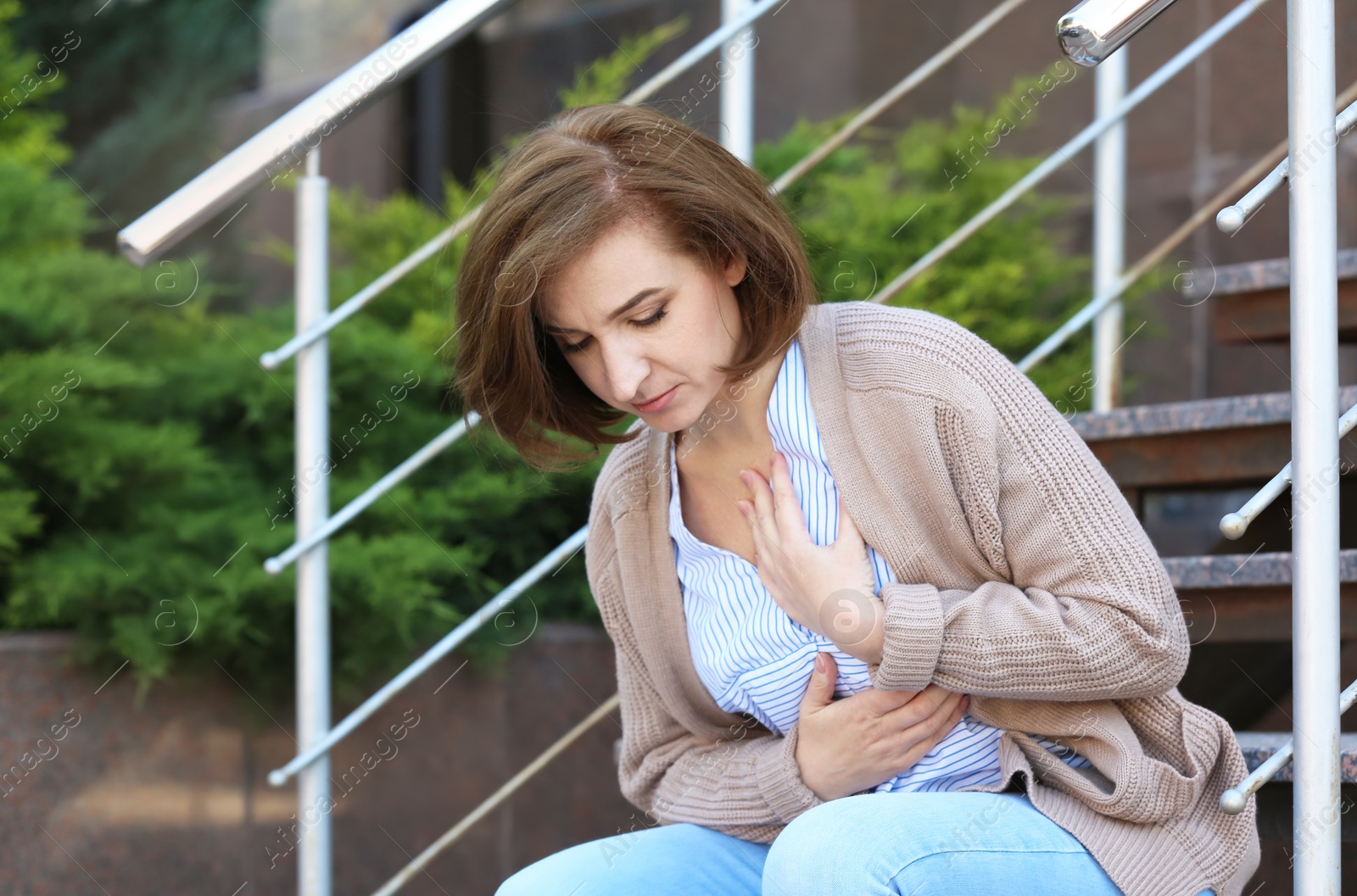 Photo of Mature woman having heart attack on stairs, outdoors