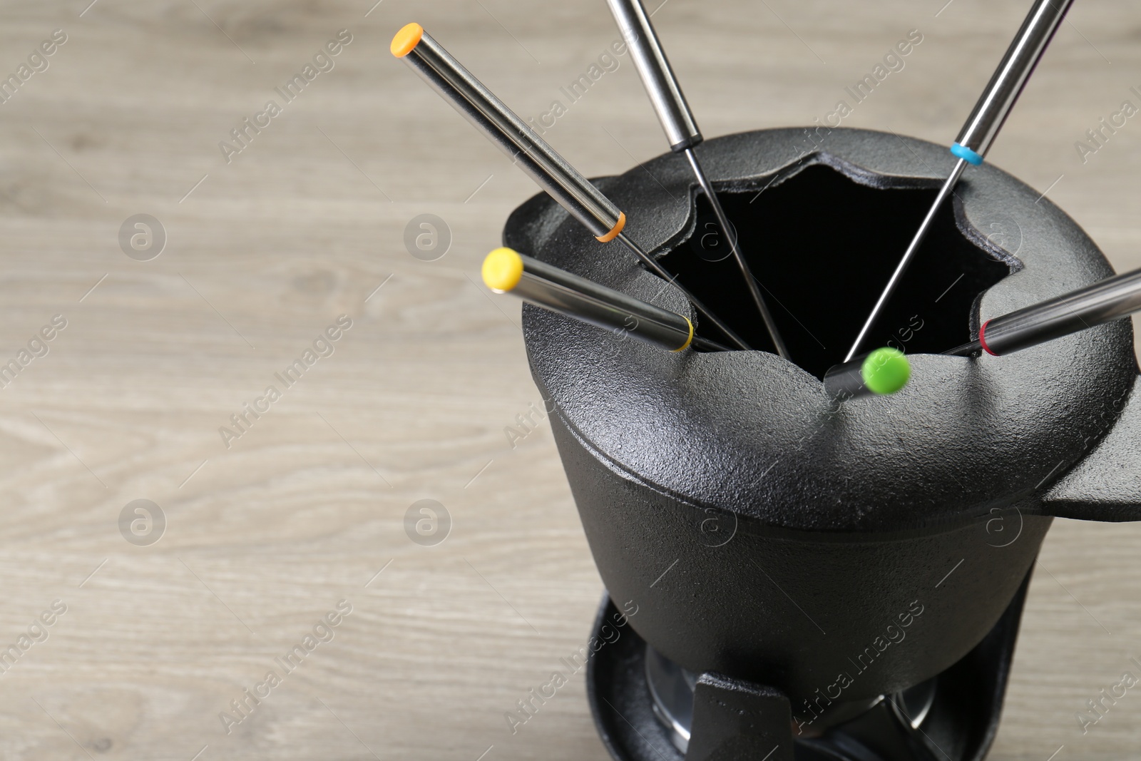 Photo of Fondue set on wooden table, space for text