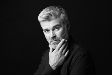 Portrait of handsome man on dark background. Black and white effect