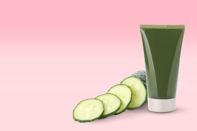 Image of Makeup remover and fresh cucumber on pink background. Space for text