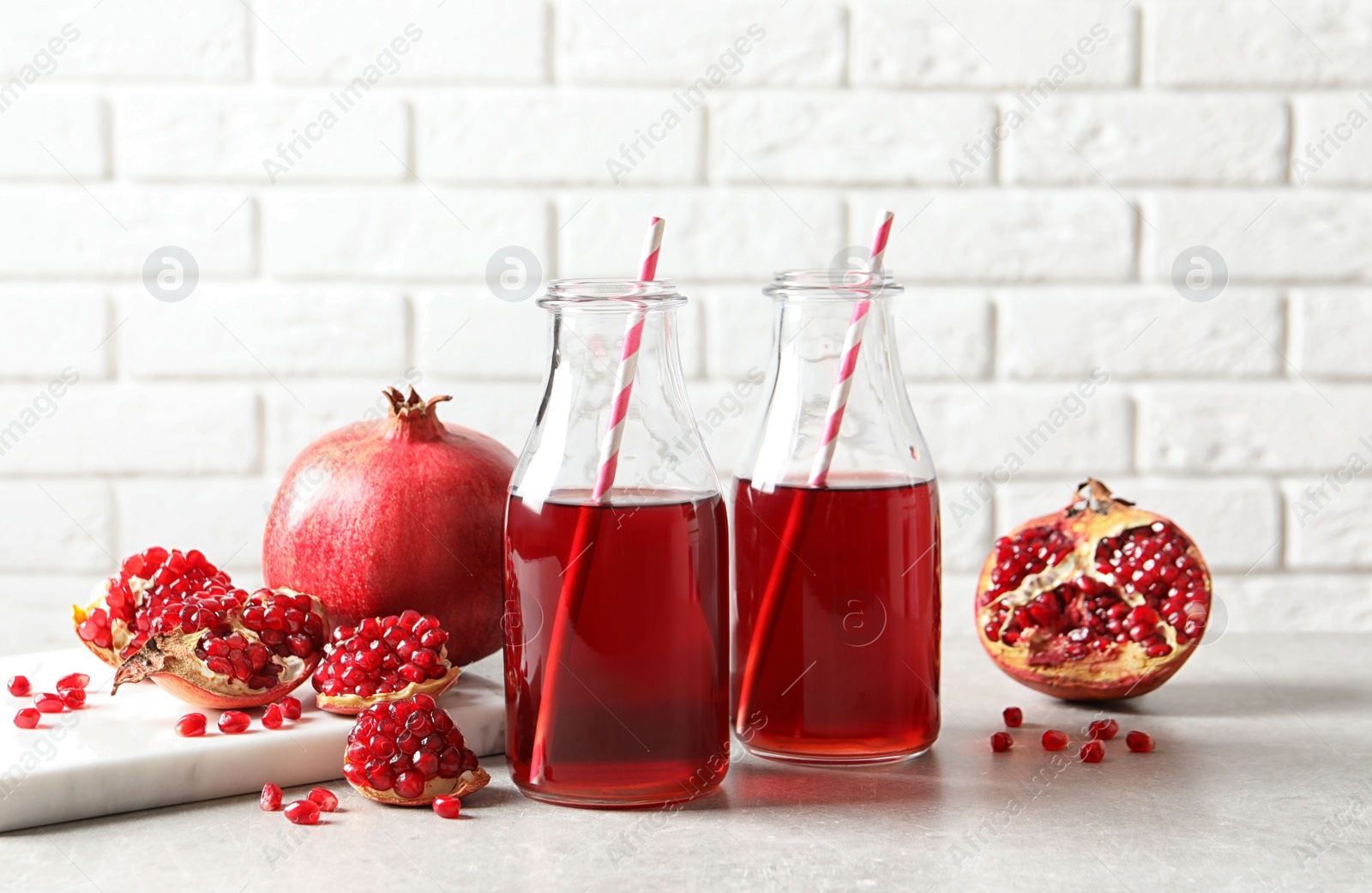 Photo of Composition with bottles of fresh pomegranate juice on table