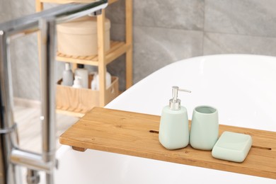 Photo of Set of bath accessories on tub in bathroom