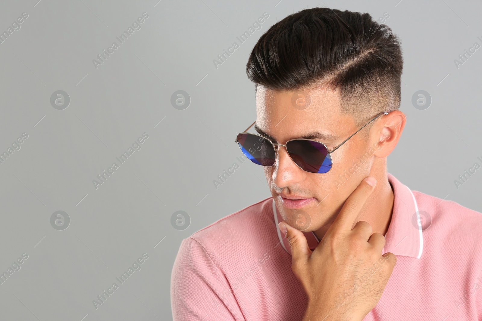 Photo of Handsome man wearing sunglasses on grey background. Space for text