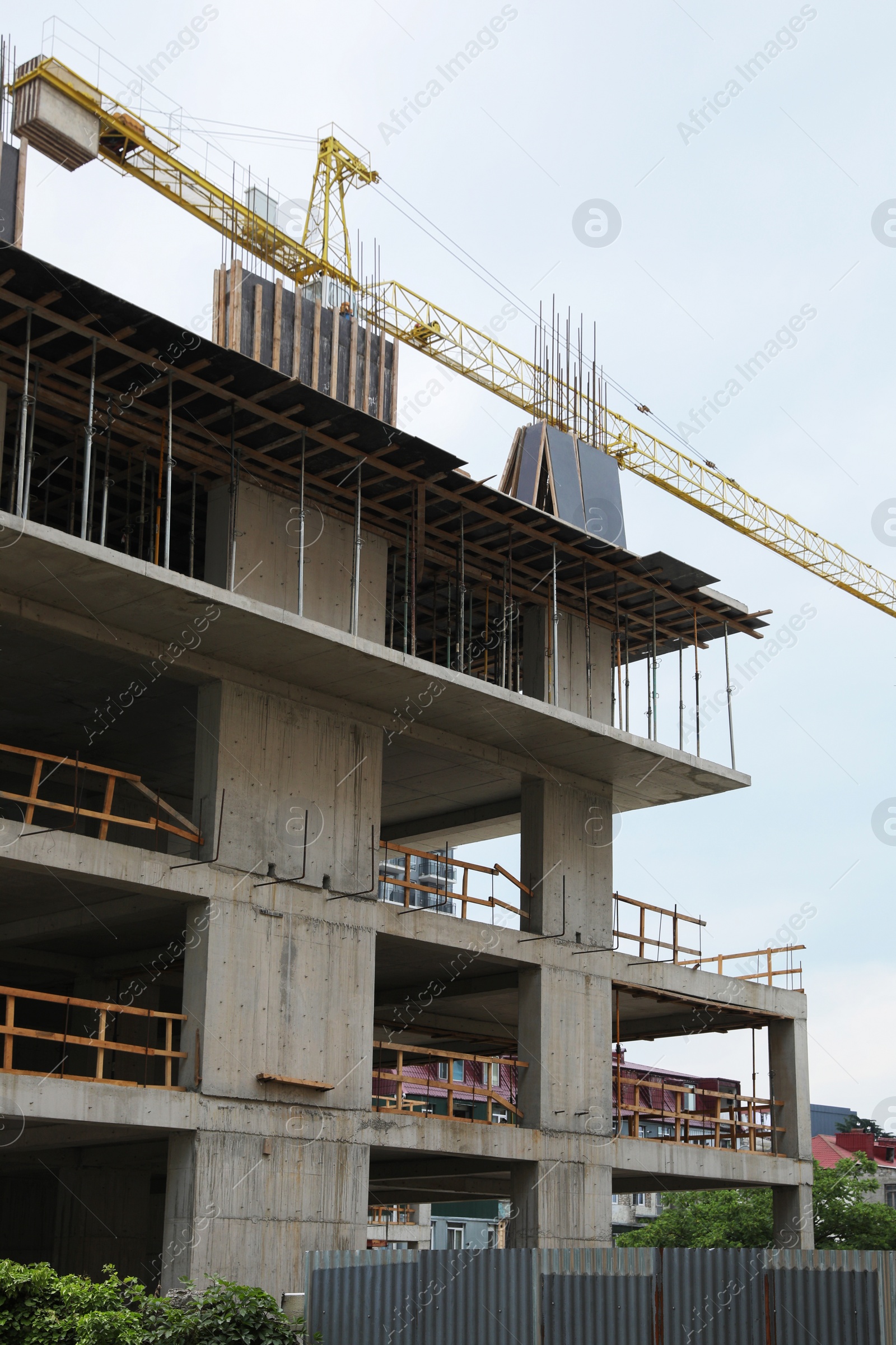 Photo of Construction site with tower crane near unfinished building