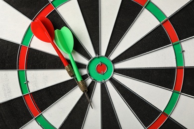 Red and green arrows on dart board, top view