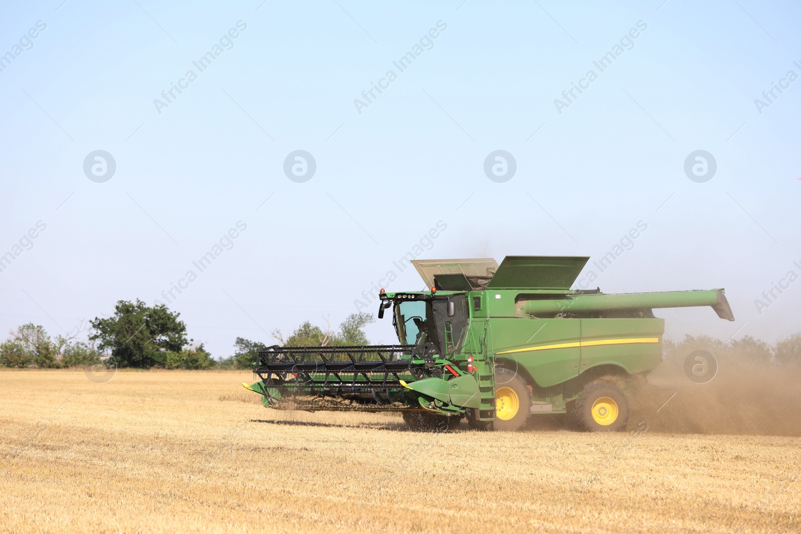 Photo of Modern combine harvester working in agricultural field