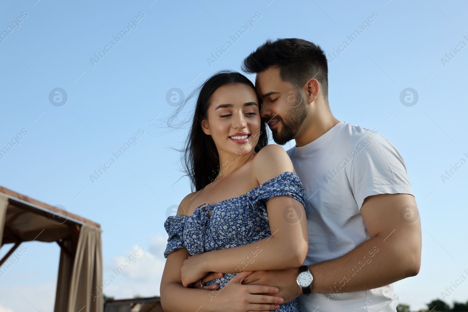 Photo of Romantic date. Beautiful couple spending time together against blue sky