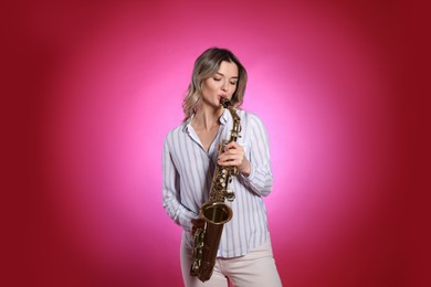 Photo of Beautiful young woman playing saxophone on red background