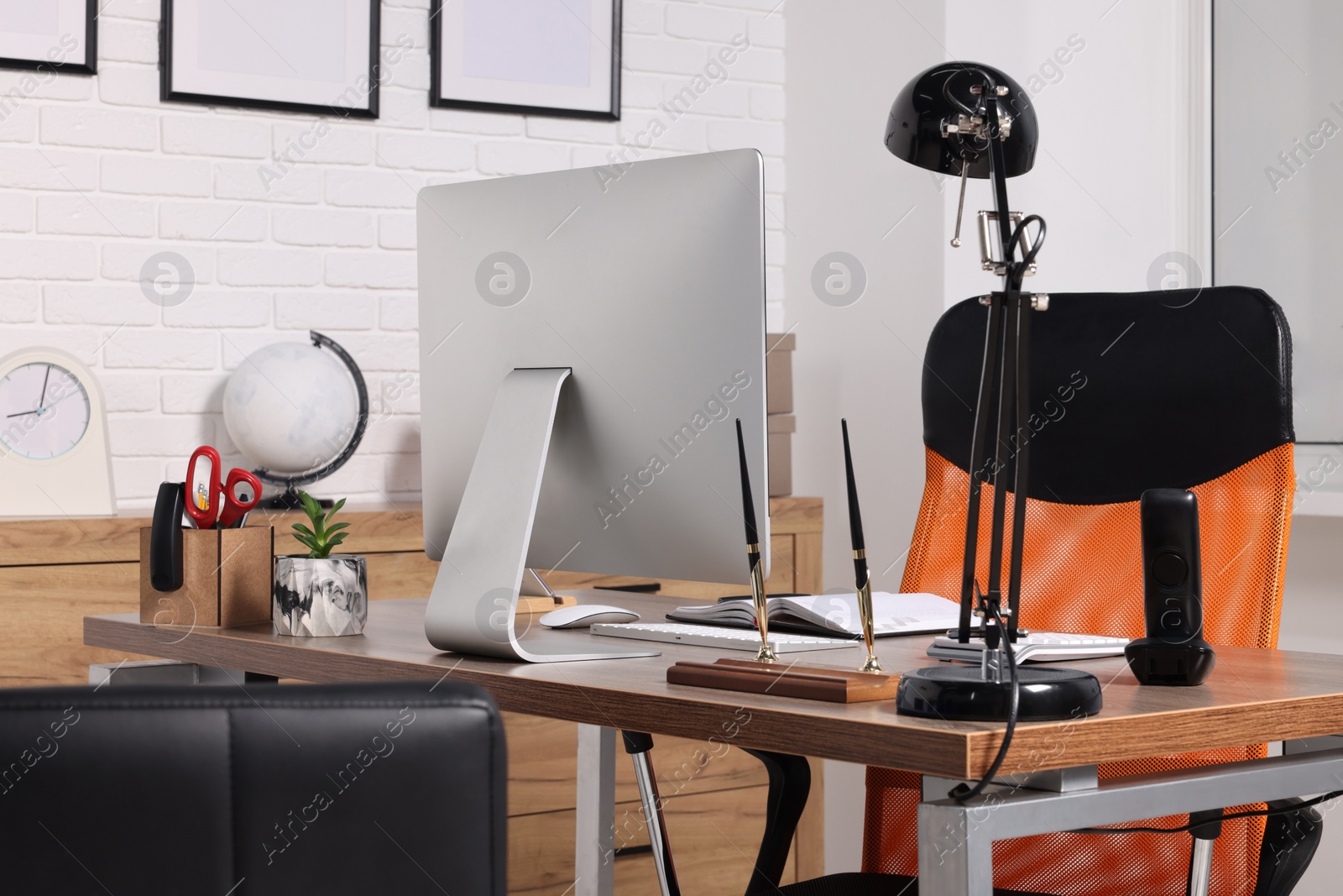 Photo of Stylish director's workplace with comfortable furniture, computer and accessories in office. Interior design