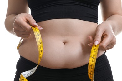 Woman measuring belly with tape on white background, closeup. Overweight problem