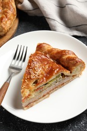 Photo of Piece of tasty homemade pie with filling on black table