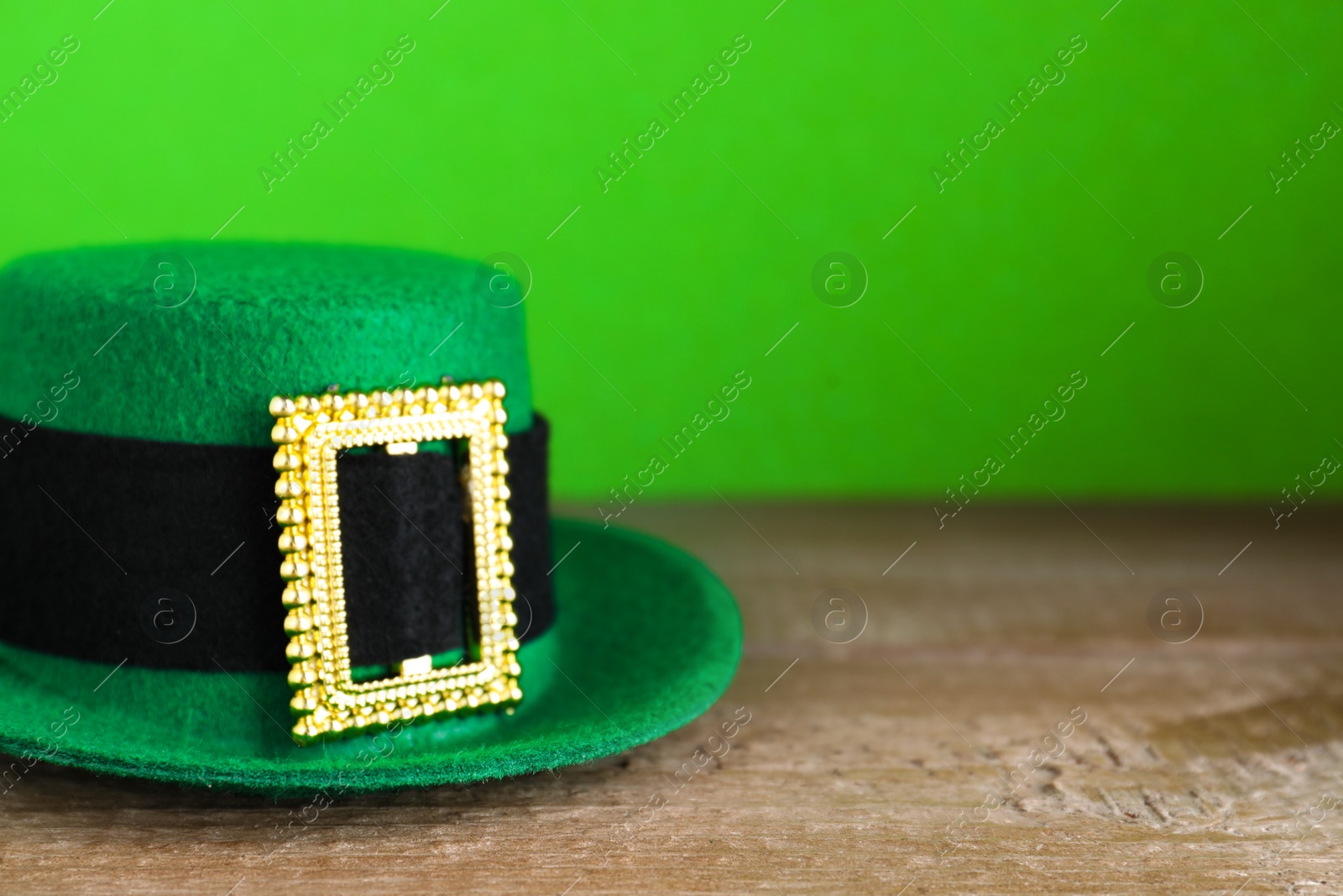 Photo of Green leprechaun hat on wooden table, space for text. St. Patrick's Day celebration