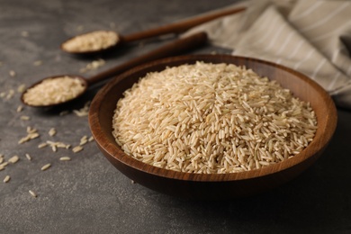 Uncooked brown rice in bowl on table