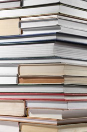 Photo of Stack of many different hardcover books as background, closeup