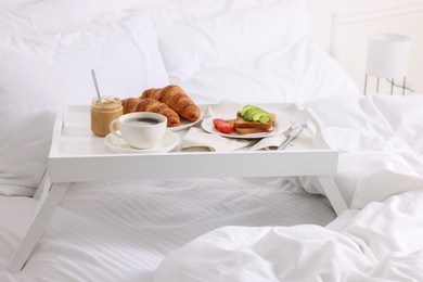 Photo of Good morning. Tray with tasty breakfast on bed