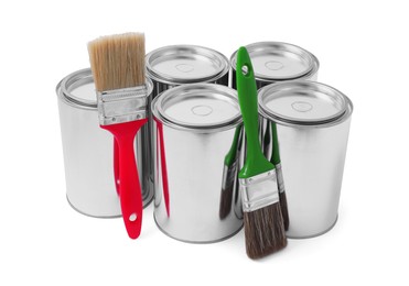 Cans of paints and brushes on white background