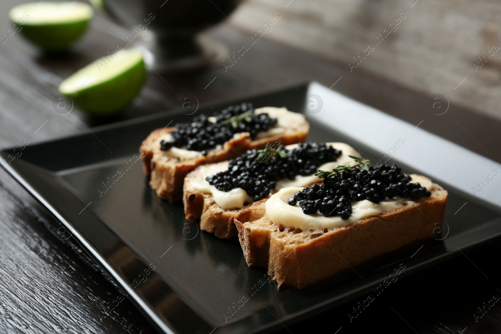 Photo of Sandwiches with black caviar on plate, closeup