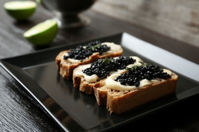 Sandwiches with black caviar on plate, closeup