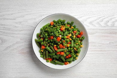 Photo of Tasty vegetable mix in bowl on white wooden table, top view