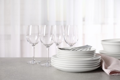 Set of clean dishes on table against blurred background