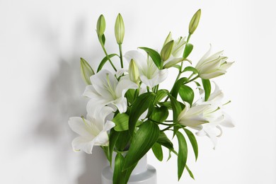 Beautiful bouquet of lily flowers in vase on white background