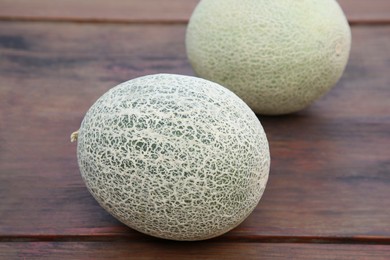 Photo of Whole ripe cantaloupe melons on wooden table