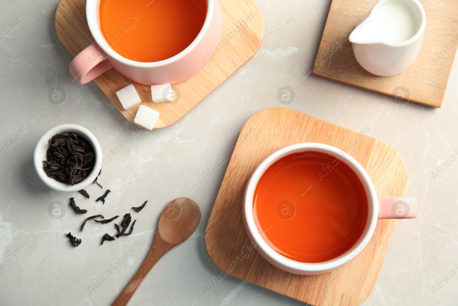 Photo of Flat lay composition with cups of black tea on table, top view