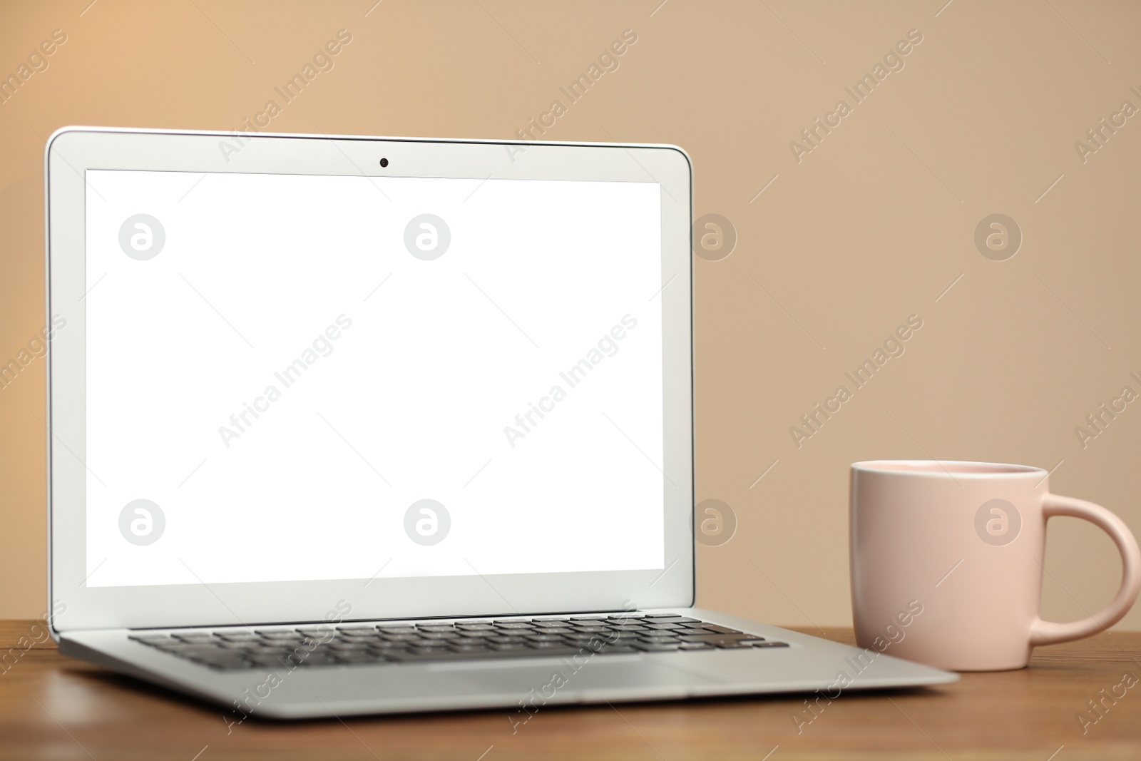 Photo of Laptop with blank screen on table indoors. Space for text