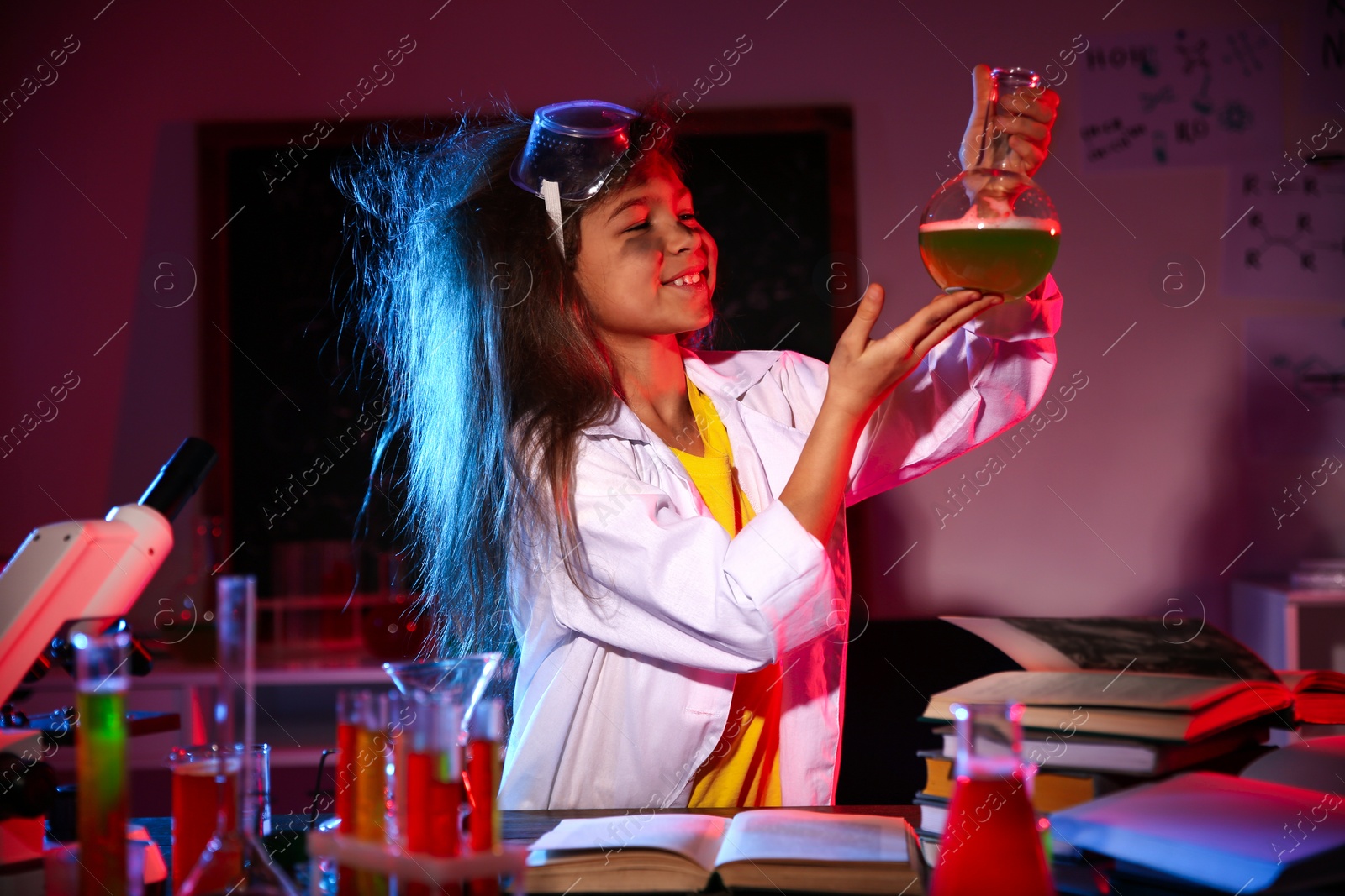 Photo of Child doing chemical research in laboratory. Dangerous experiment