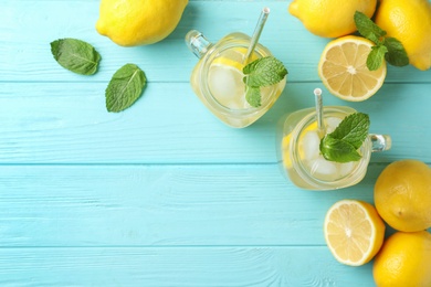 Photo of Natural lemonade with mint on light blue wooden table, flat lay and space for text. Summer refreshing drink