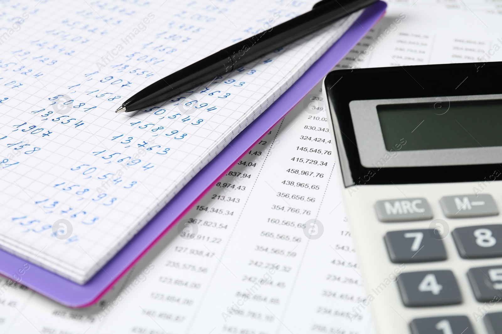 Photo of Calculator, notebook and pen on document with data, closeup