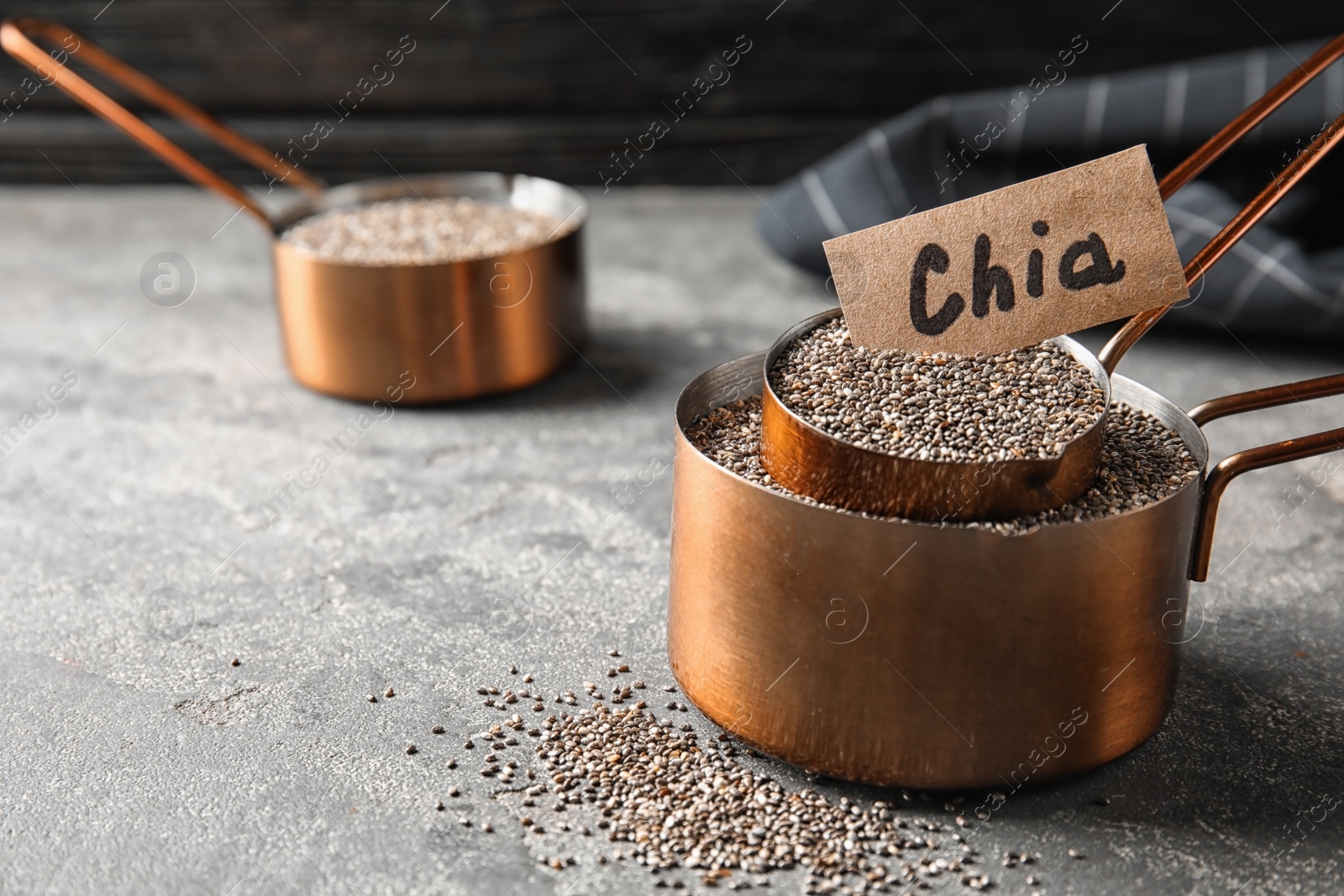 Photo of Saucepans with chia seeds on grey table, space for text