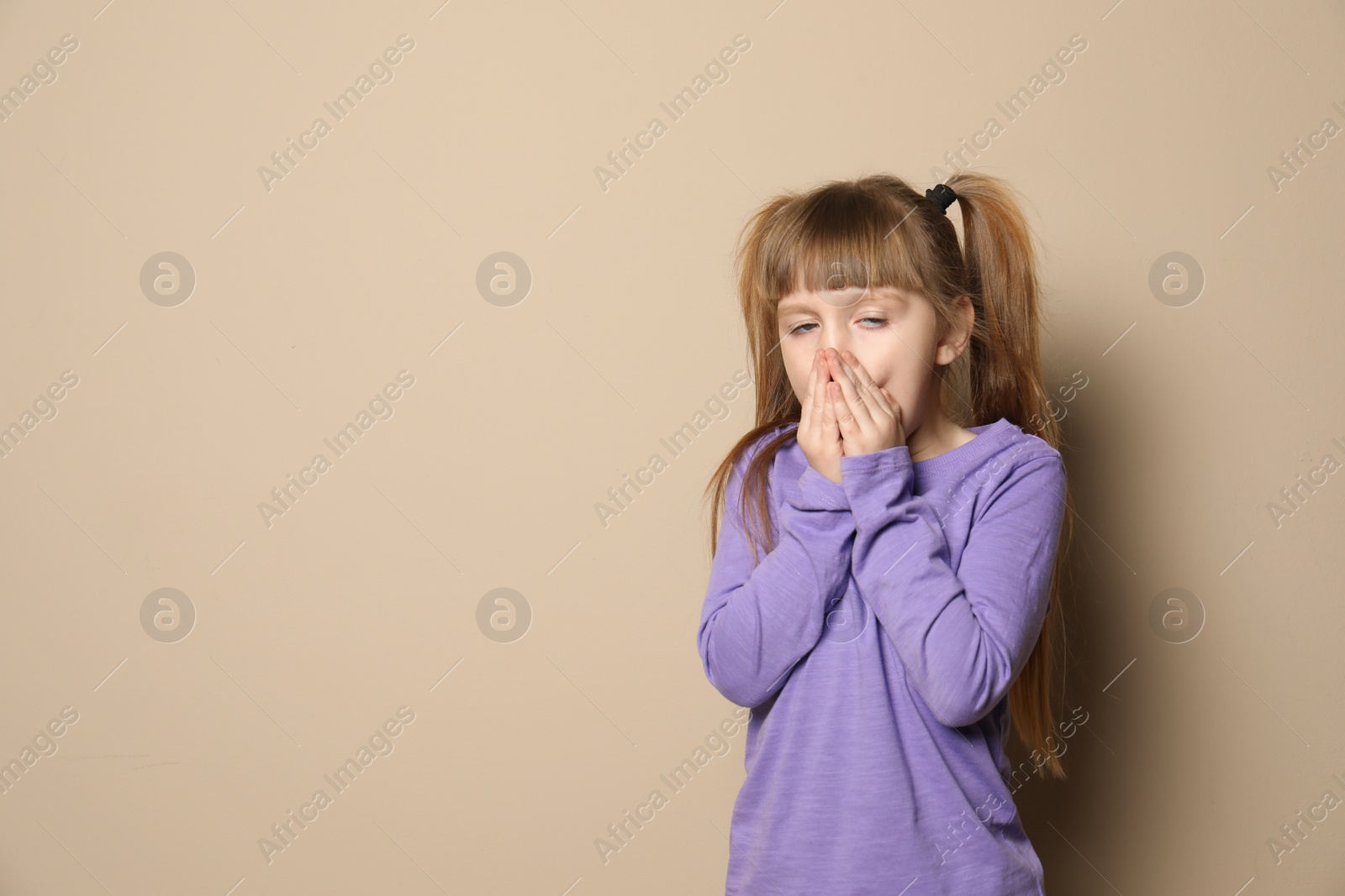 Photo of Cute little girl coughing against color background. Space for text