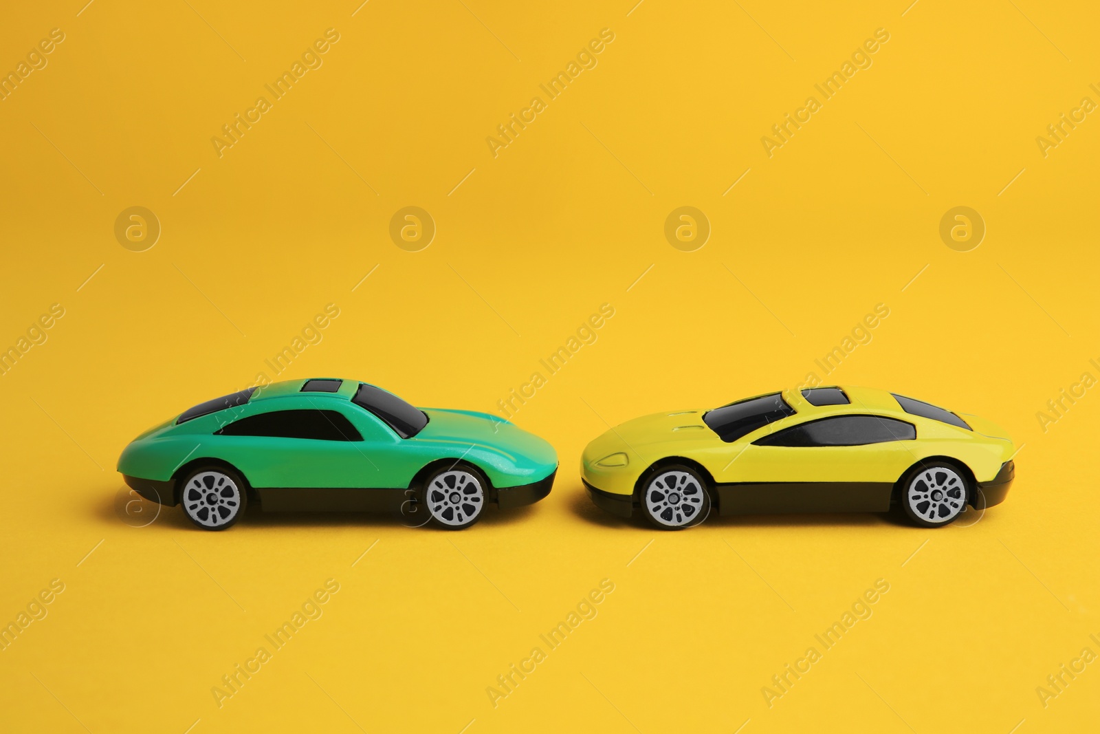 Photo of Bright cars on yellow background. Children`s toys