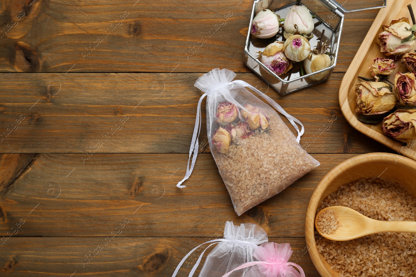 Photo of Scented sachet with dried roses and sea salt on wooden table, flat lay. Space for text