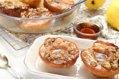 Delicious quinces baked with honey and walnuts on white table