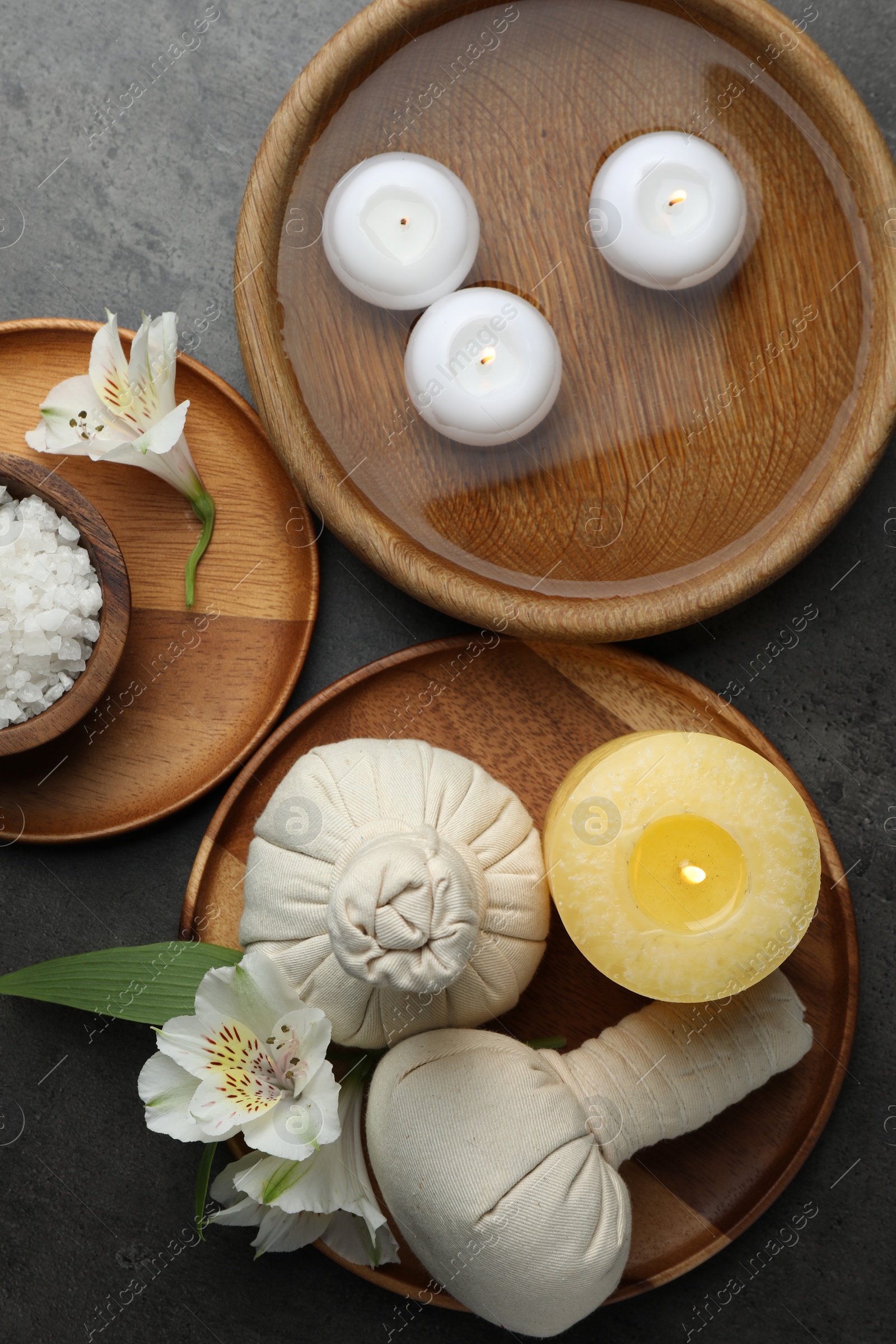 Photo of Flat lay composition with different spa products and lily flowers on grey table