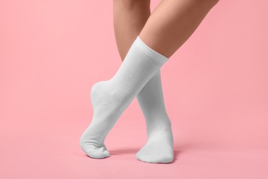 Photo of Woman in stylish white socks on pink background, closeup