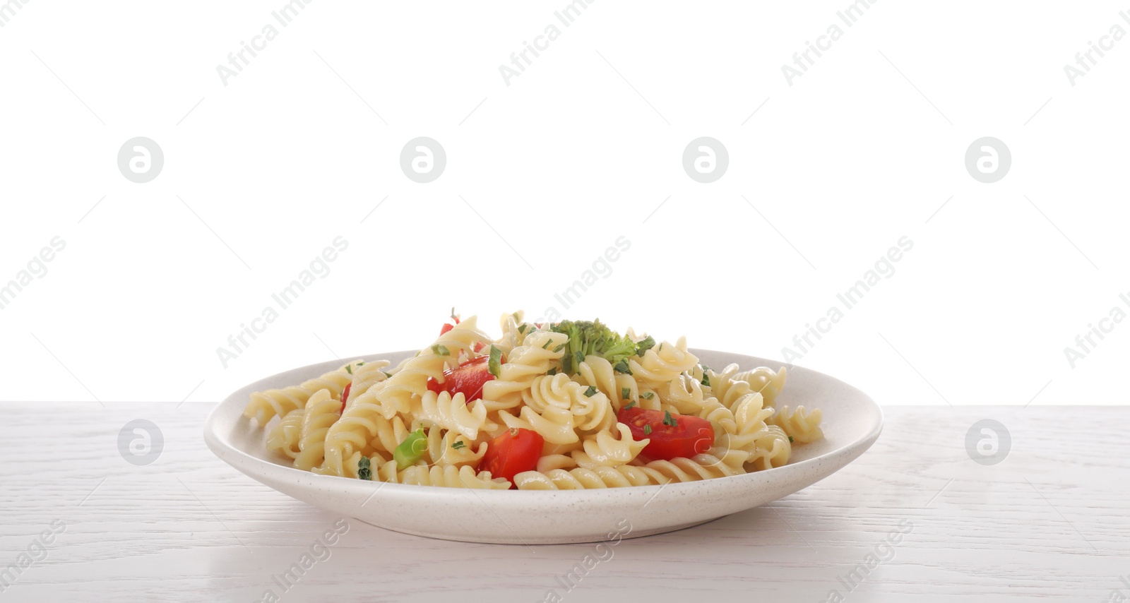 Photo of Tasty pasta with broccoli and cherry tomatoes on wooden table against white background