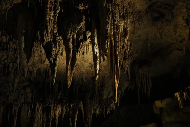 Picturesque view of many stalactite formations in dark cave