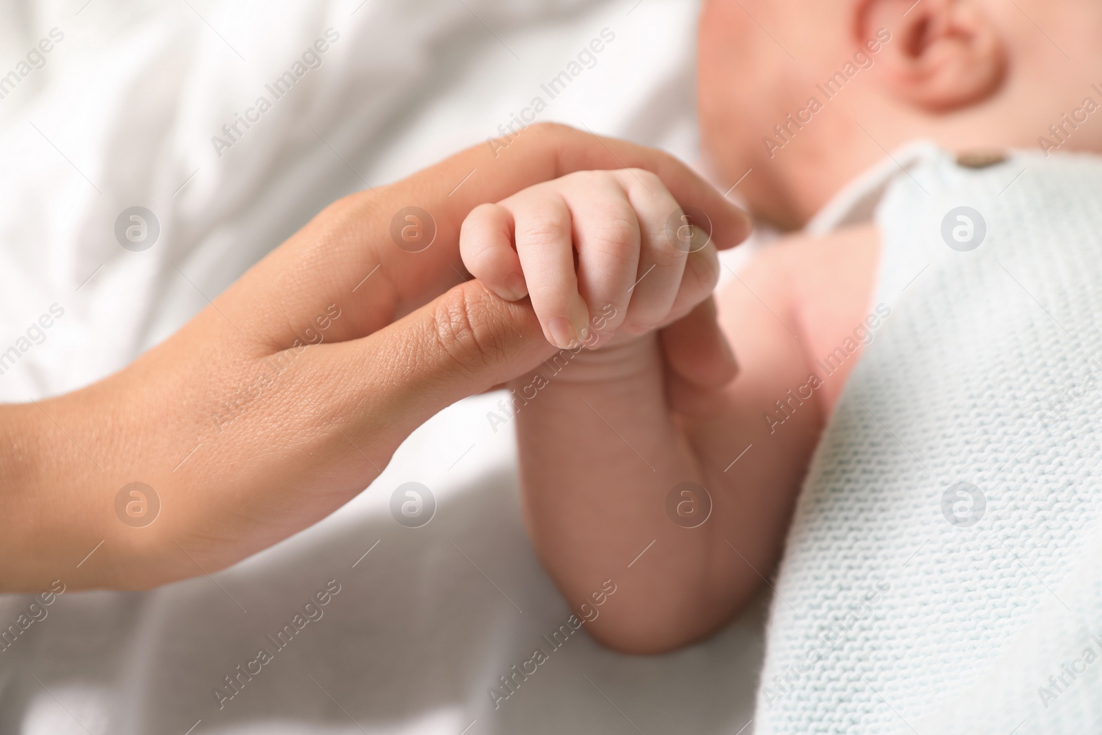 Photo of Mother and her newborn baby on bed, closeup