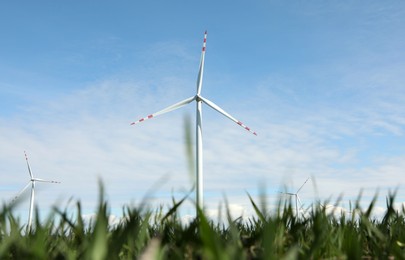 Modern wind turbines in field on sunny day. Alternative energy source