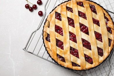 Photo of Delicious fresh pie and cherries on light grey marble table, flat lay