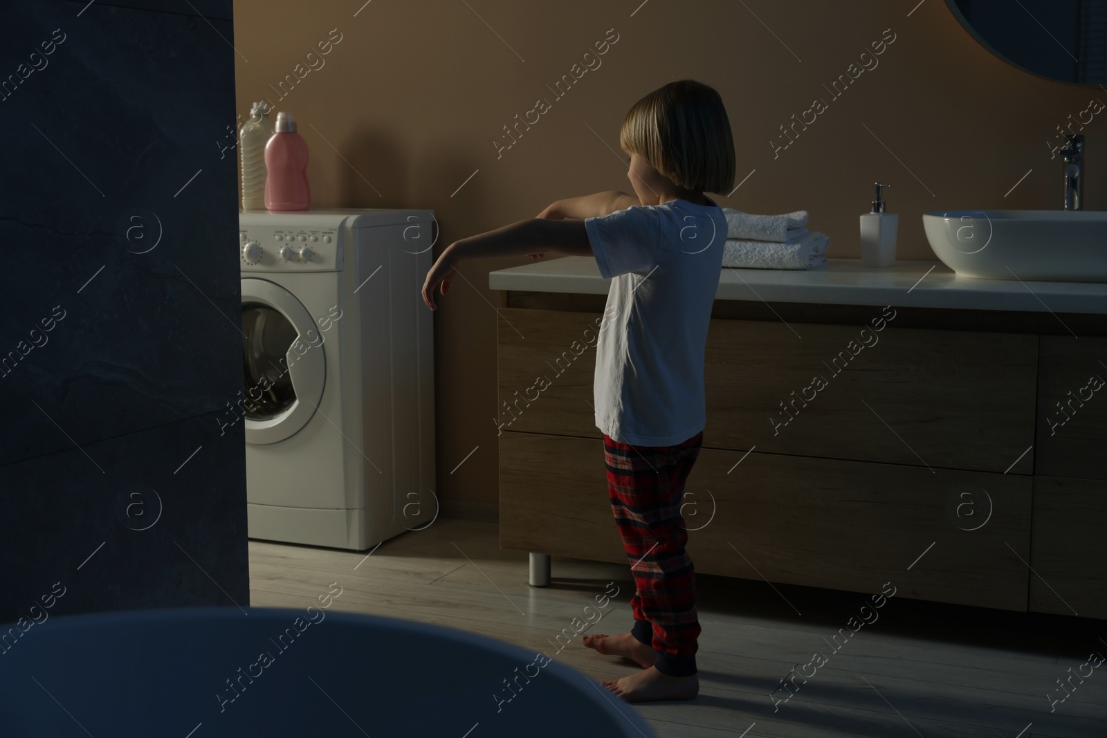 Photo of Boy in pajamas sleepwalking indoors at night