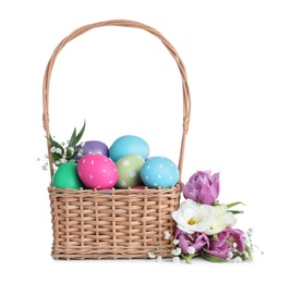 Photo of Wicker basket with bright painted Easter eggs and spring flowers on white background