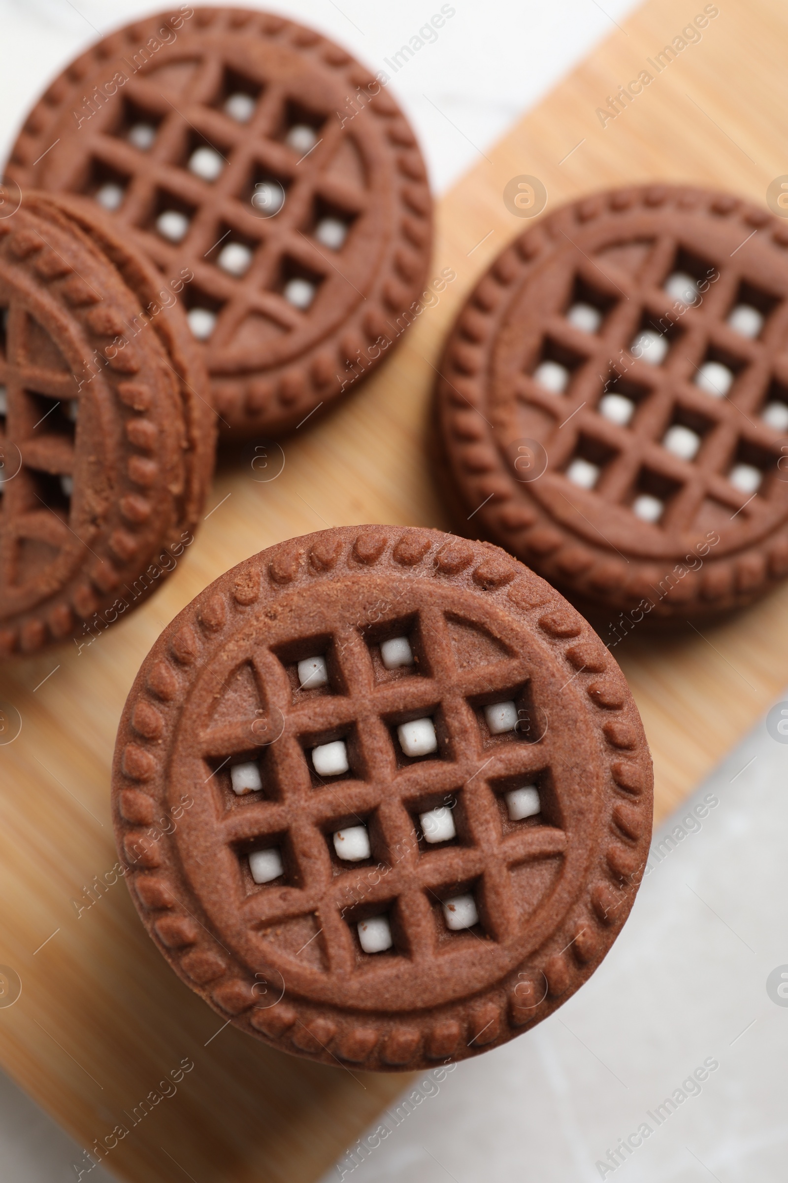 Photo of Tasty chocolate sandwich cookies with cream on light table, flat lay